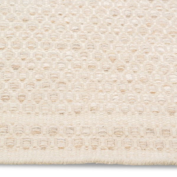 Macro detail of the Theo hand-woven rug surface highlighting the raised, chunky honeycomb texture in ivory cream wool.