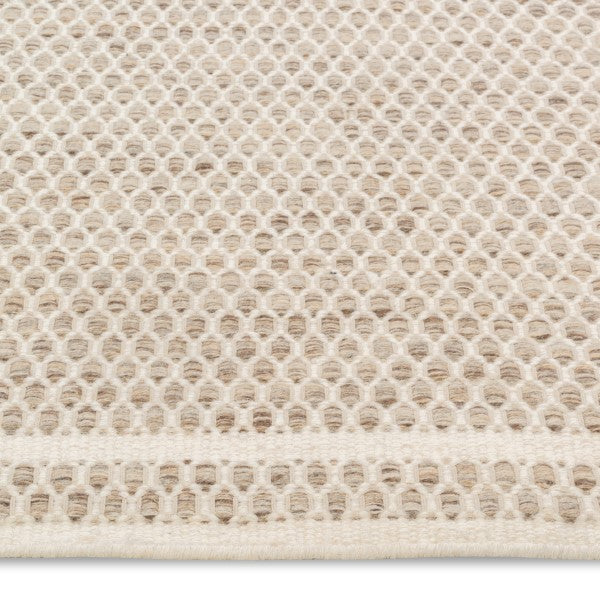 Macro view of the husk Theo rug's surface highlighting the intricate chunky basket weave texture woven from tonal oatmeal wool yarns