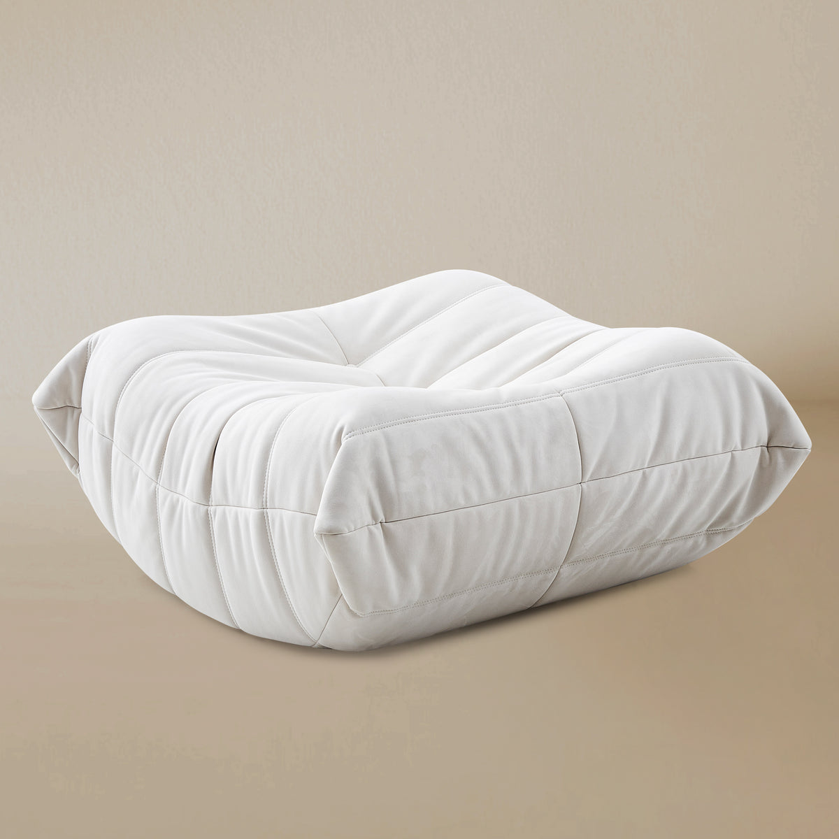 Angle view of the White TOGO ottoman on a beige background