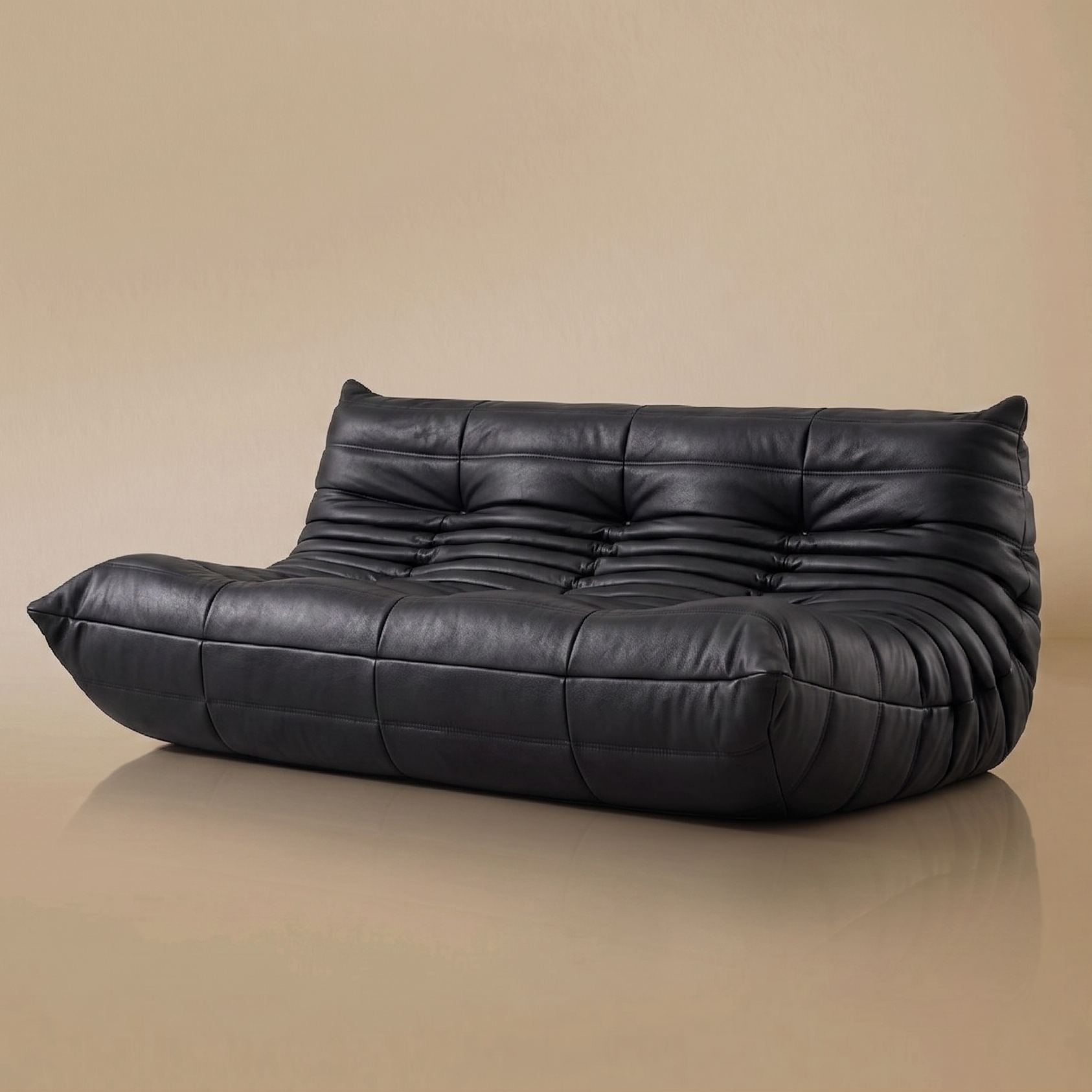 Black leather TOGO Three Seater Lounger on a beige background