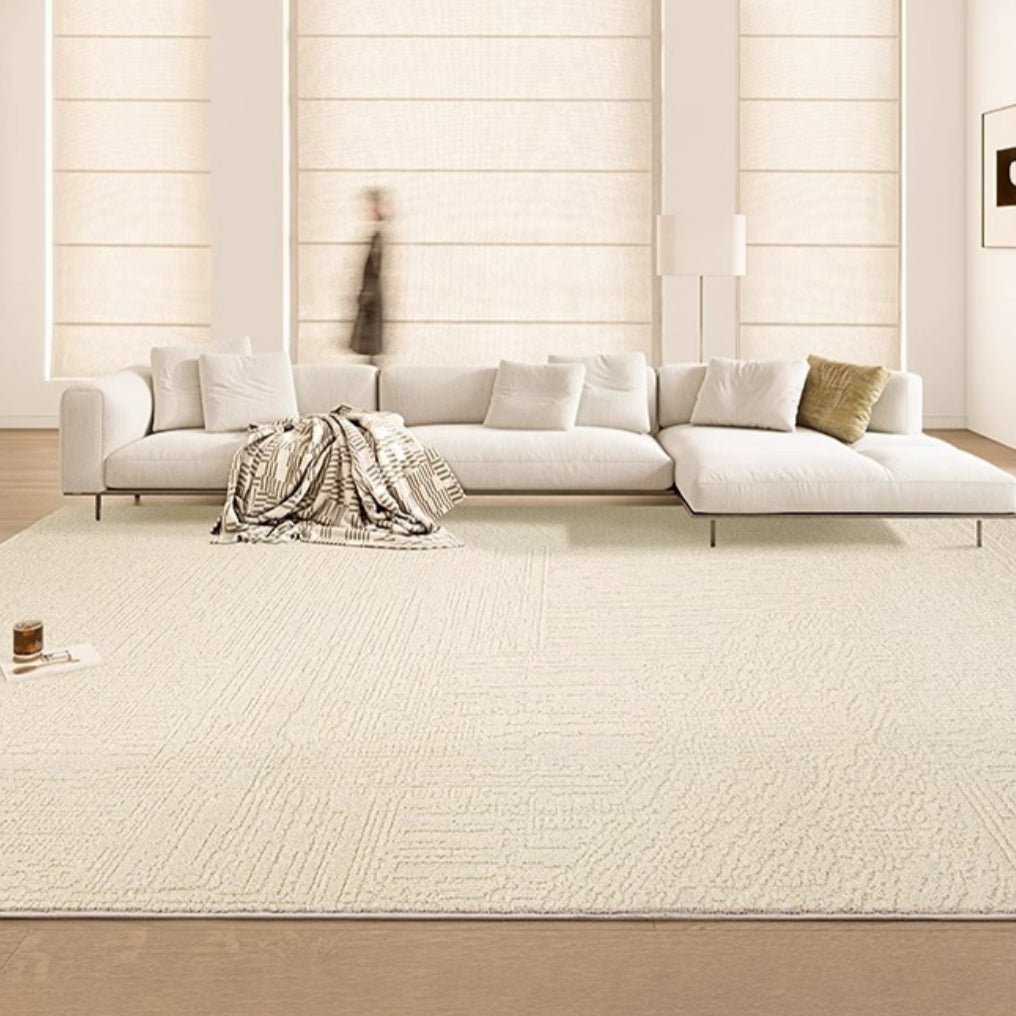 A large, plush, creamy beige area rug in a bright living room setting, complementing the neutral color scheme.