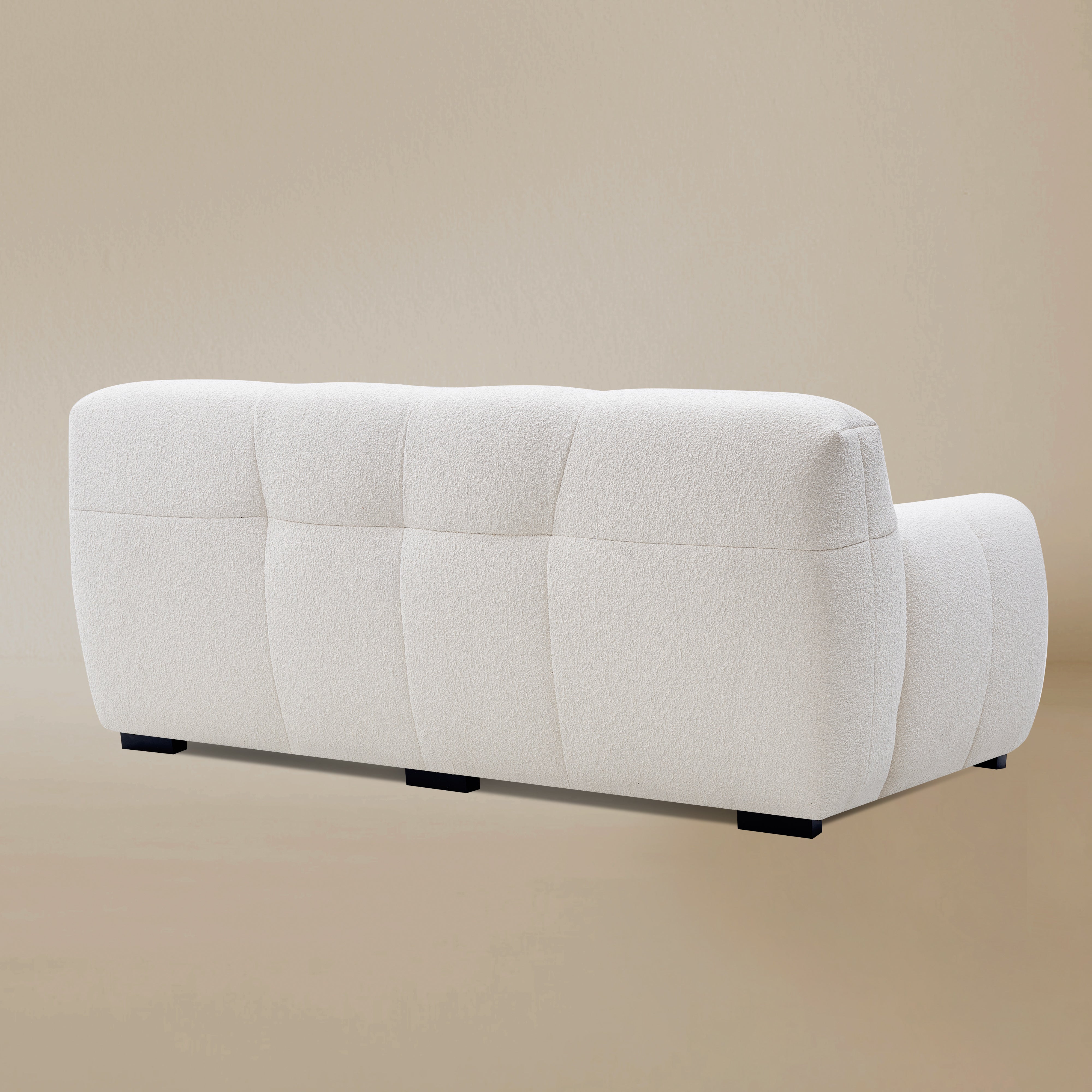 Back angle view of the Gummy loveseat variant, highlighting the plush vertical tufting, boucle fabric, and low-profile silhouette.