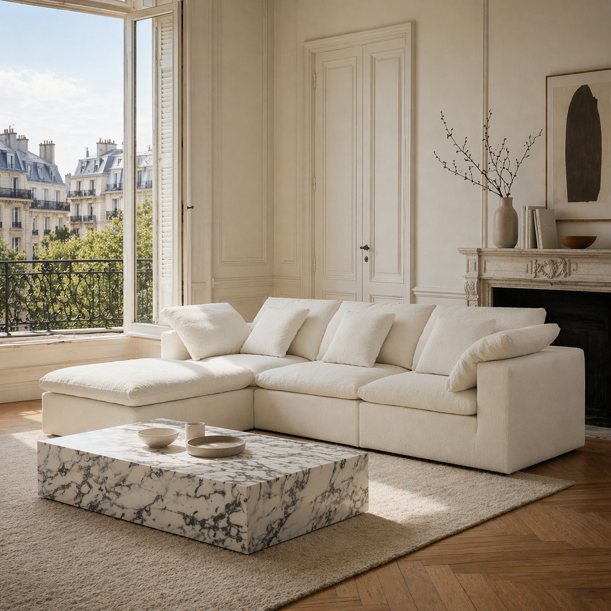 Ivory sectional sofa in a living room with marble coffee table and decorative elements.
