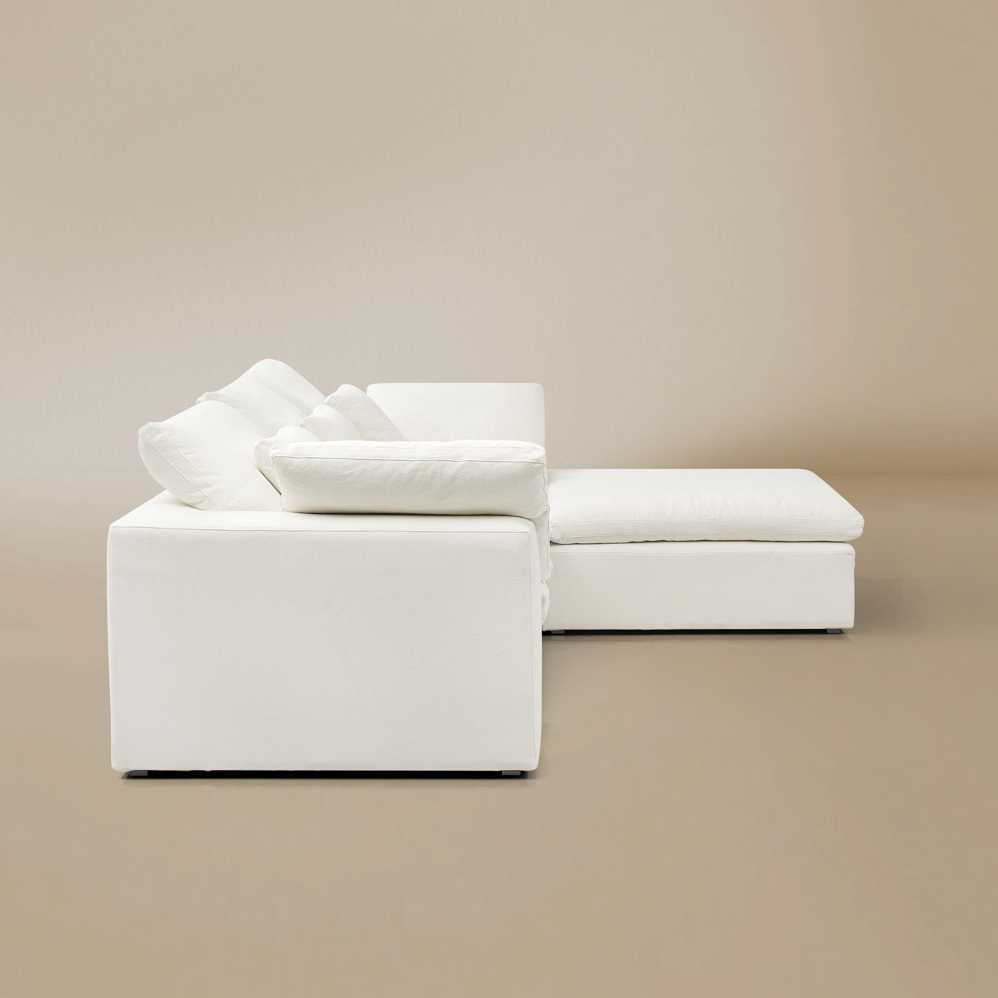 Side view of ultra softness modular sofa two seater with ottoman on a beige studio background