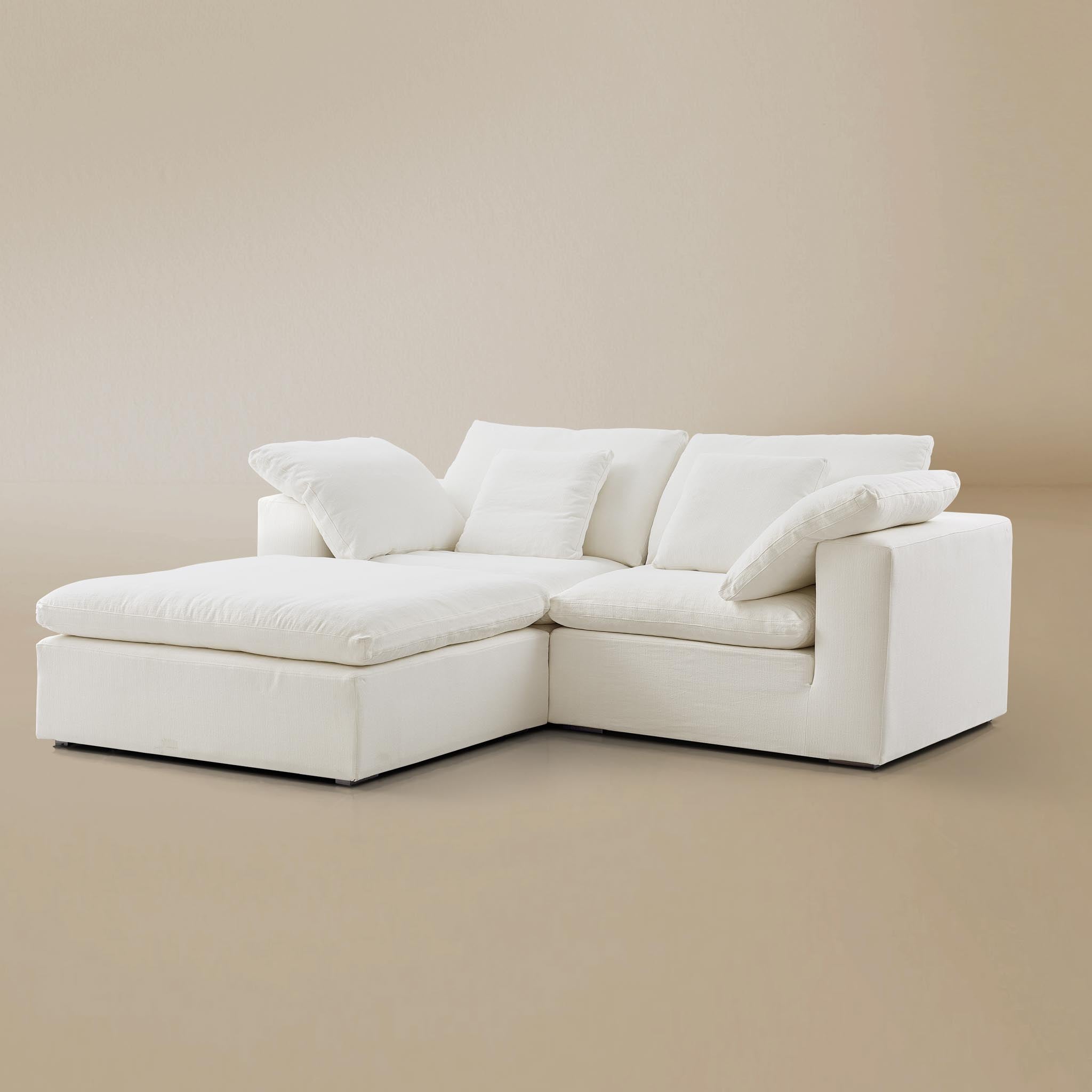 Side profile view of the premium two-seater linen cloud couch paired with a matching modular ottoman.