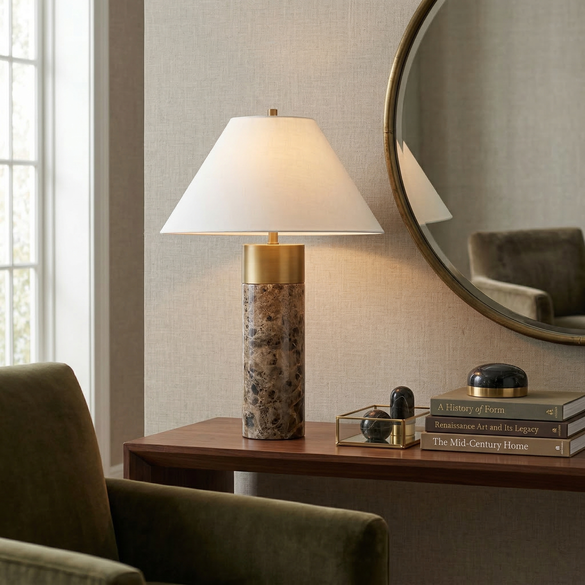 The Valance marble table lamp styled on a wood console table with decorative books and a round mirror in a modern interior.