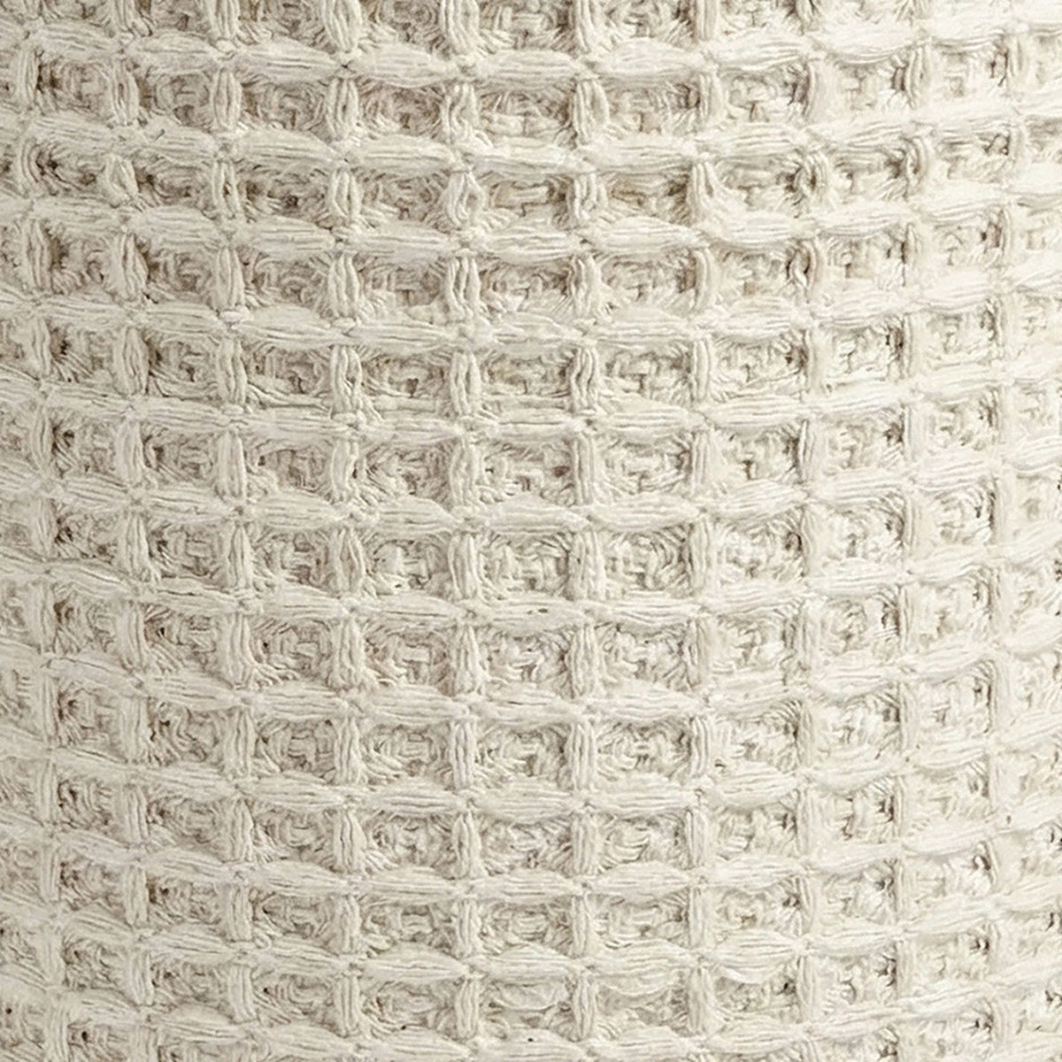 Close-up of a textured beige fabric with a grid pattern