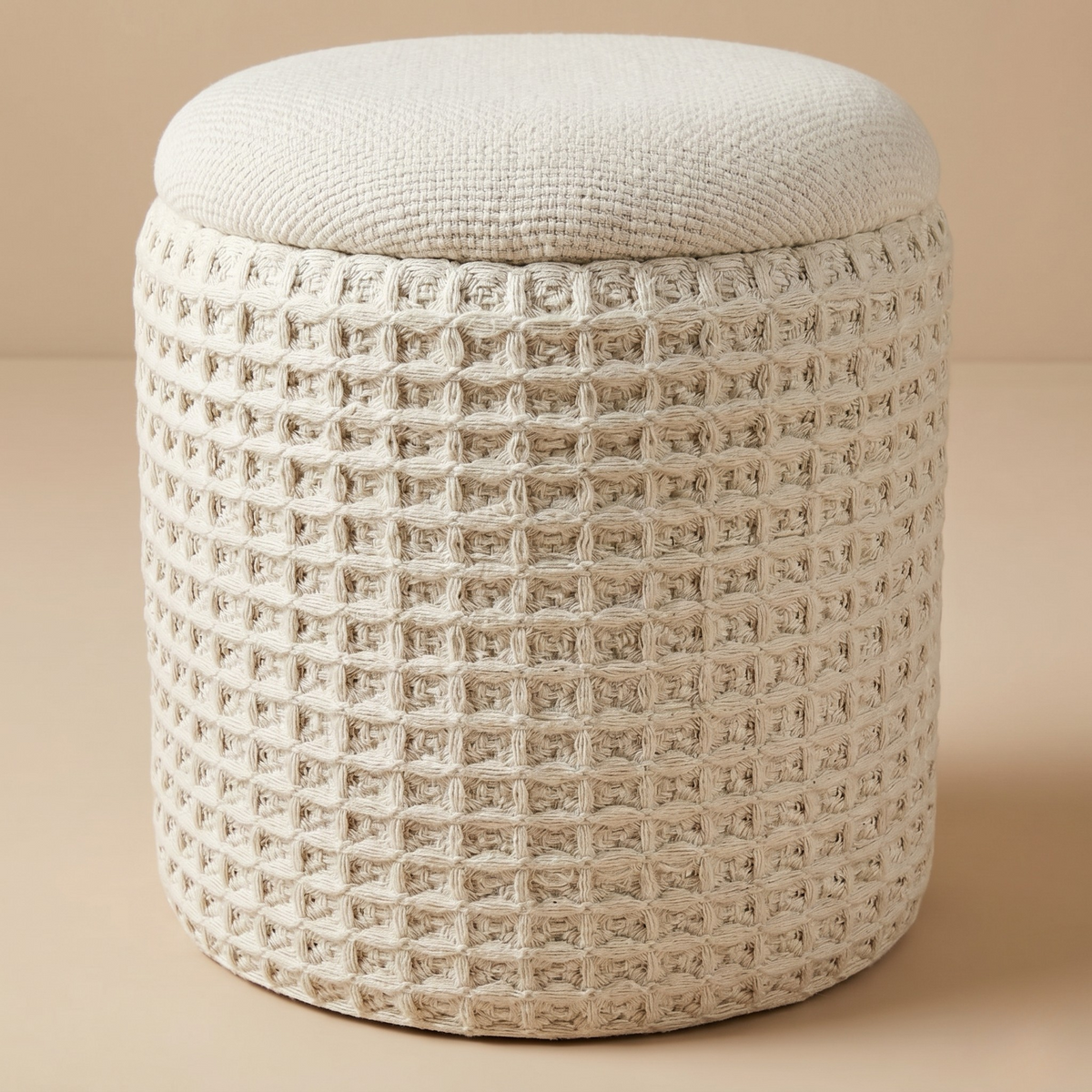 Textured round ottoman on a beige background