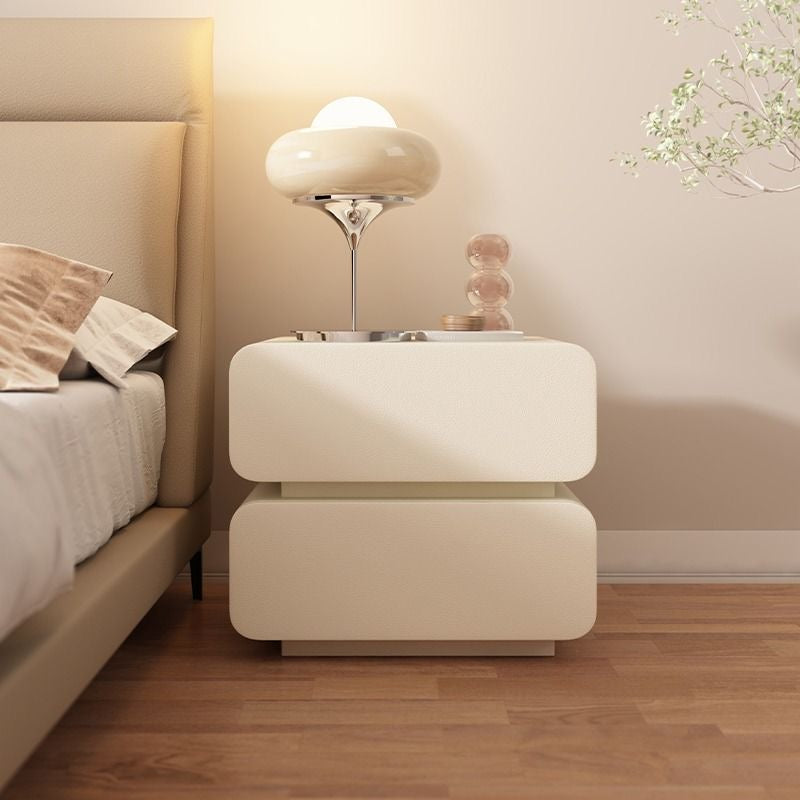 A beige modern wood and leather nightstand with two tiers, placed against a neutral background.