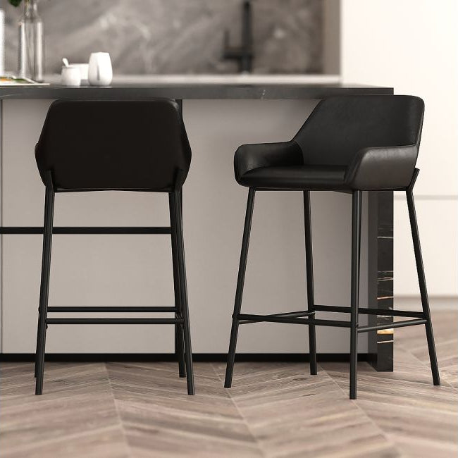 Two black bar stools in a modern kitchen setting.