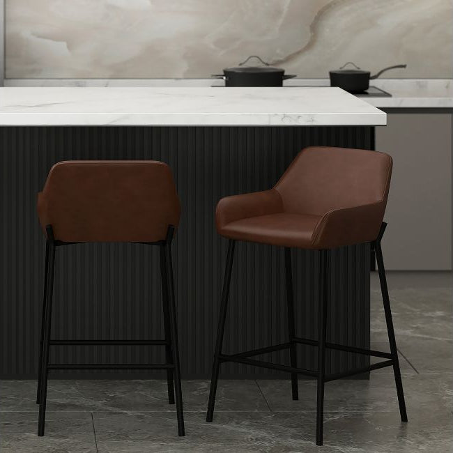 Two brown bar stools in a kitchen setting with a marble backsplash.