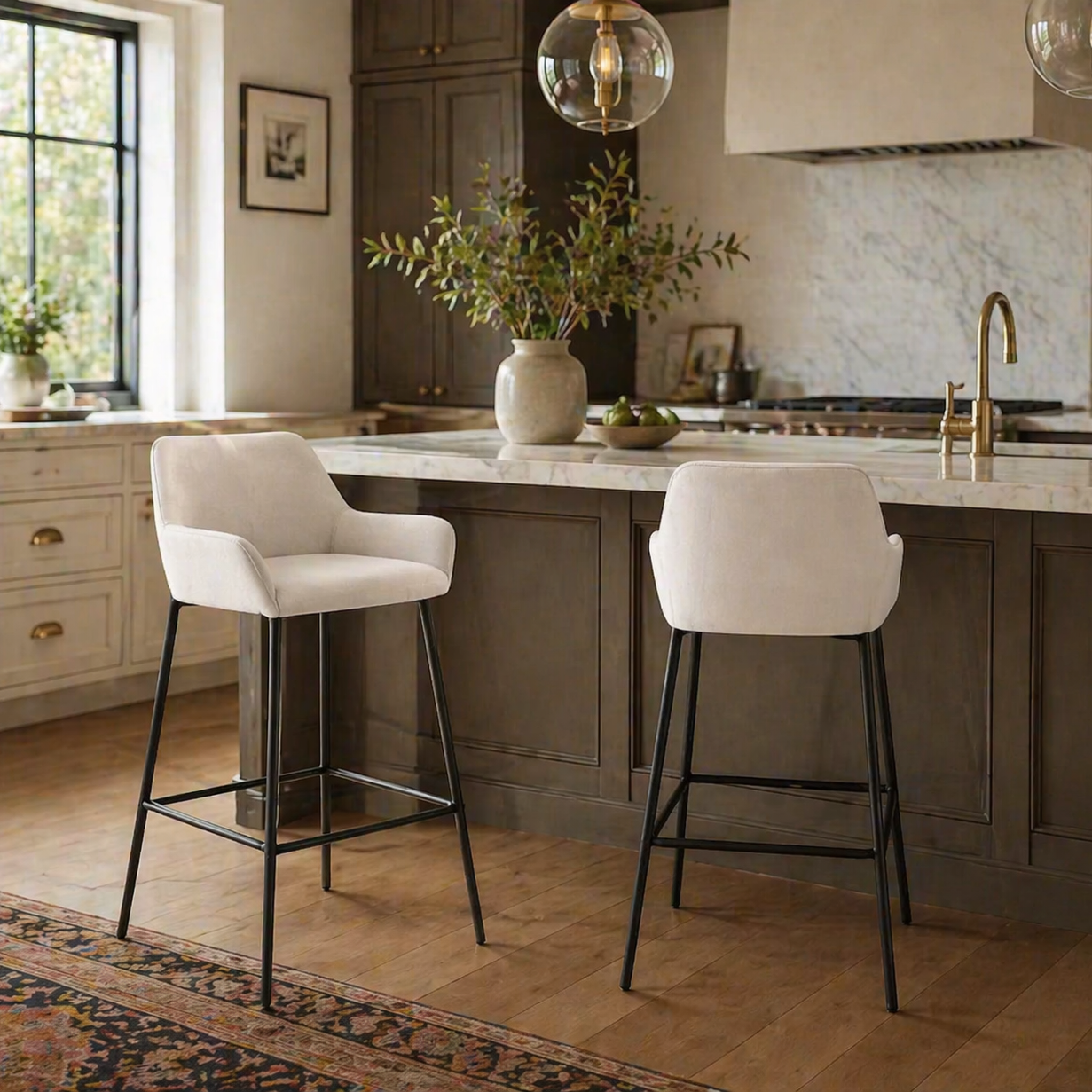 Two white bar stools in a modern kitchen with marble countertops and wooden flooring.