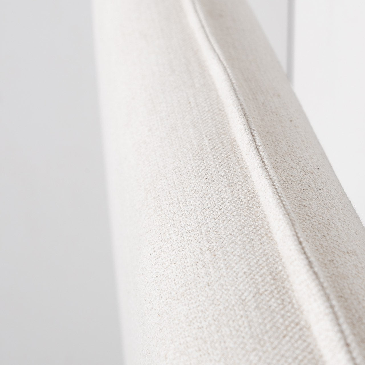Angled macro shot of the Vivienne bed's headboard showcasing the clean lines of the flanged edge and the soft fabric weave.