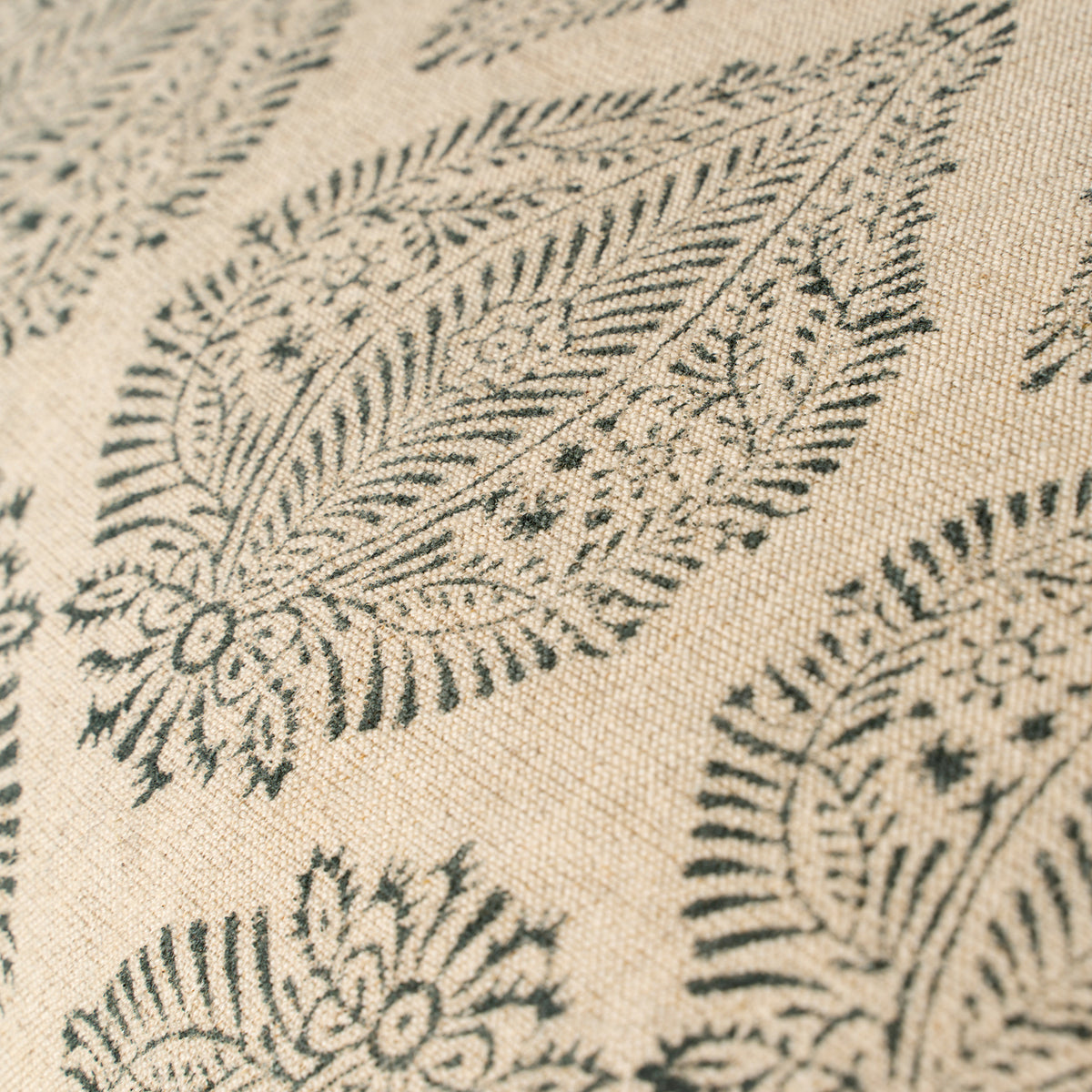 Close-up of a textured fabric with black floral patterns on a beige background