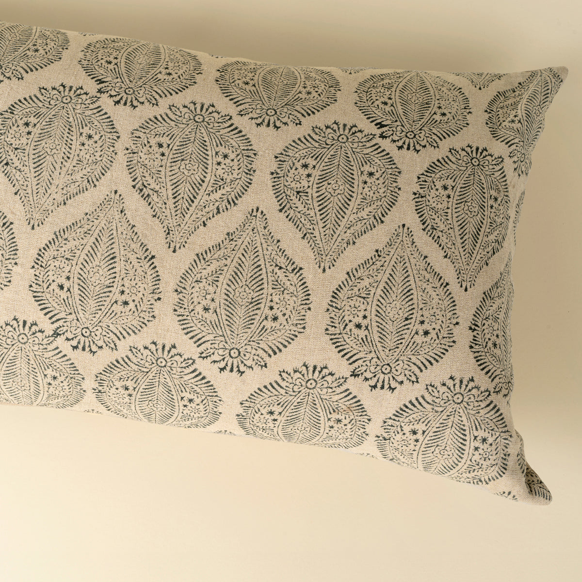 Decorative pillow with black leaf pattern on beige background