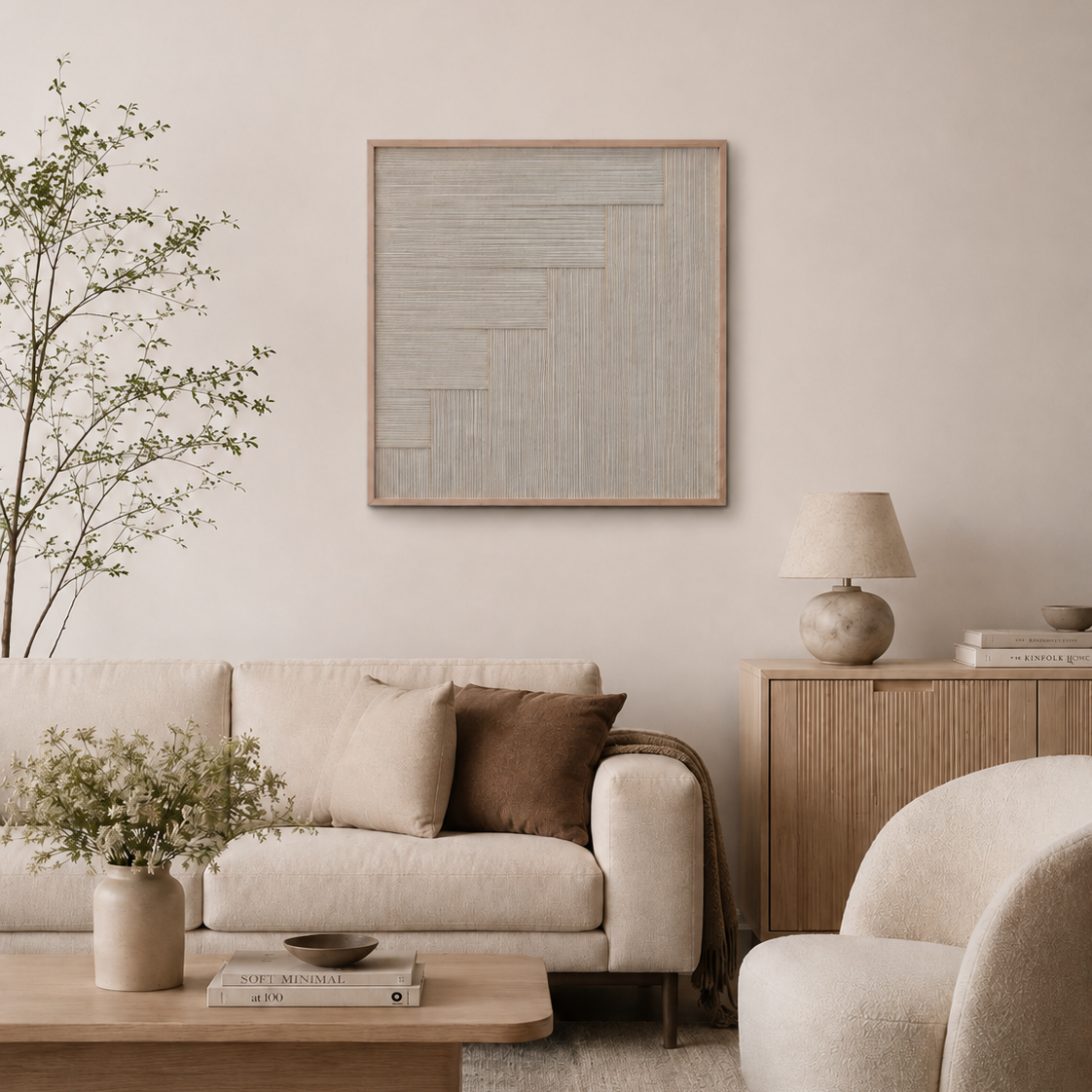 A styled living room featuring a square abstract wood art print with a light gray and beige geometric pattern in a light wood frame, hung on a beige wall above a cream-colored sofa.