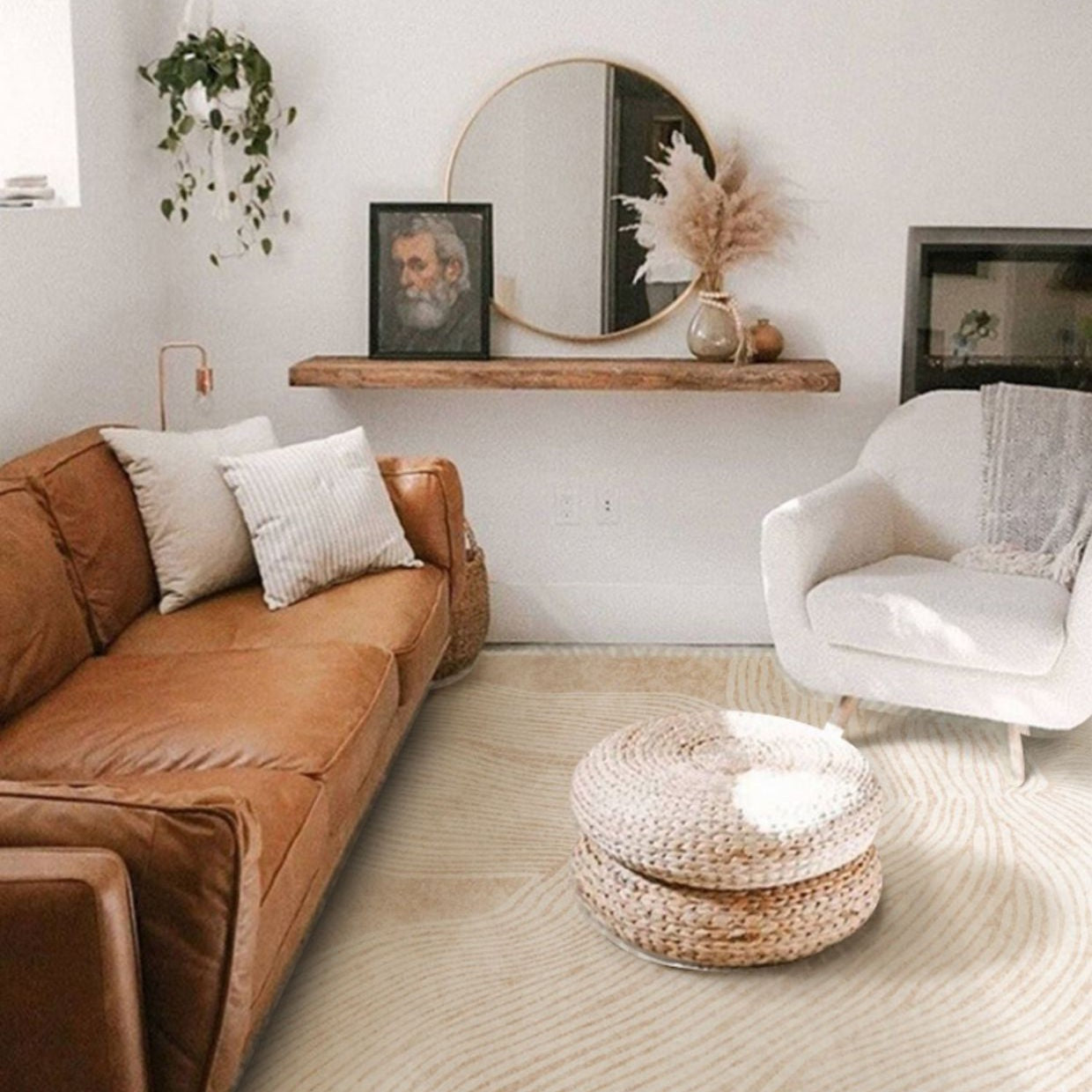 Cozy living room styled with the Woven Whisper Rug, paired with a tan leather sofa, white accent chair, and woven ottoman