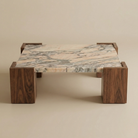 Coffee table with marble top and wooden frame on a beige background