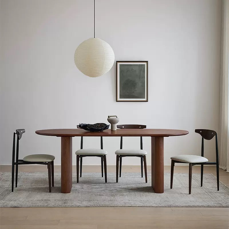Adrian solid wood dining table with walnut finish styled with four chairs in modern living room