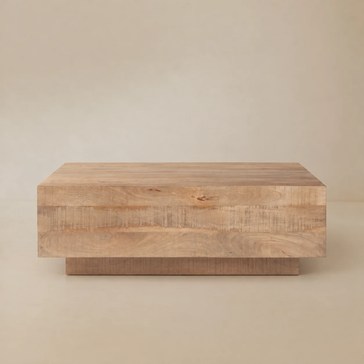 Front view of the Aero wood coffee table highlighting the horizontal plank design and recessed plinth base.