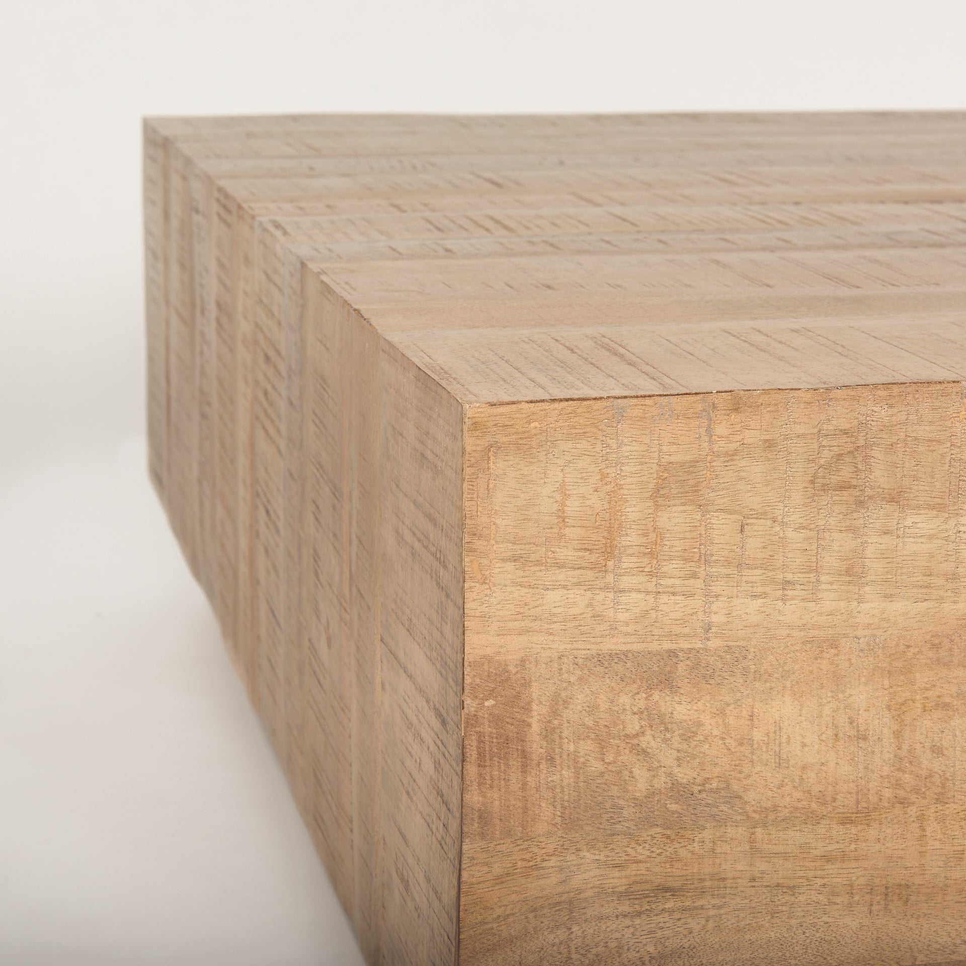 Macro close-up of the Aero table corner showcasing the natural mango wood grain and distressed finish.