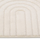 Close-up of a textured beige rug with concentric circular pattern