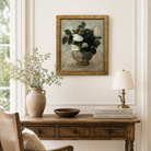 Nestled corner of a room with a wooden desk, chair, lamp, and framed artwork.