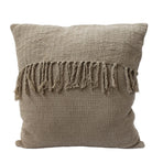 Beige textured pillow with tassels on a light gray background