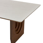 Corner detail of the Arcadian Dining Table with white travertine top and wooden base on a white background