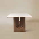 Side view of the Arcadian Dining Table with a white travertine top and walnut wooden legs on a beige background