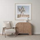 Arco fluted cabinet styled in a neutral living room next to a beige armchair and desert artwork.