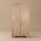 Arco Fluted Mango Wood Curio Cabinet featuring a tall geometric routed 2-door pattern and natural finish.
