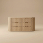 Arden oak dresser featuring a curved silhouette with vertical fluted wood texture and six spacious drawers with brass finger pulls