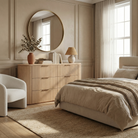 Arden oak fluted dresser styled in a warm neutral bedroom with a round mirror, ceramic decor, and a boucle armchair