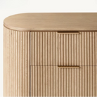 Macro detail of the Arden dresser showing the minimalist brass finger pull handles and precision-milled vertical wood fluting