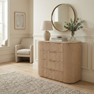 Arden curved wood dresser used as an entryway console table, styled with a gold mirror and vase of eucalyptus