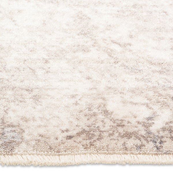 Close-up of the soft, plush pile and tidy bound edge on the neutral beige and grey Aria abstract area rug.
