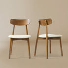 Pair of Ash Classic dining chairs with walnut ash wood frames and cream padded seats