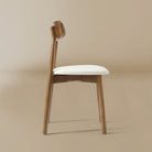 Side profile of the Ash Classic dining chair featuring a solid wood frame with a dark walnut finish, curved backrest, and cream upholstered seat