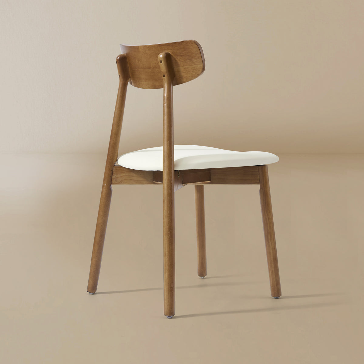 Back angle view of the Ash Classic dining chair featuring a solid wood frame with a dark walnut finish, curved backrest, and cream upholstered seat