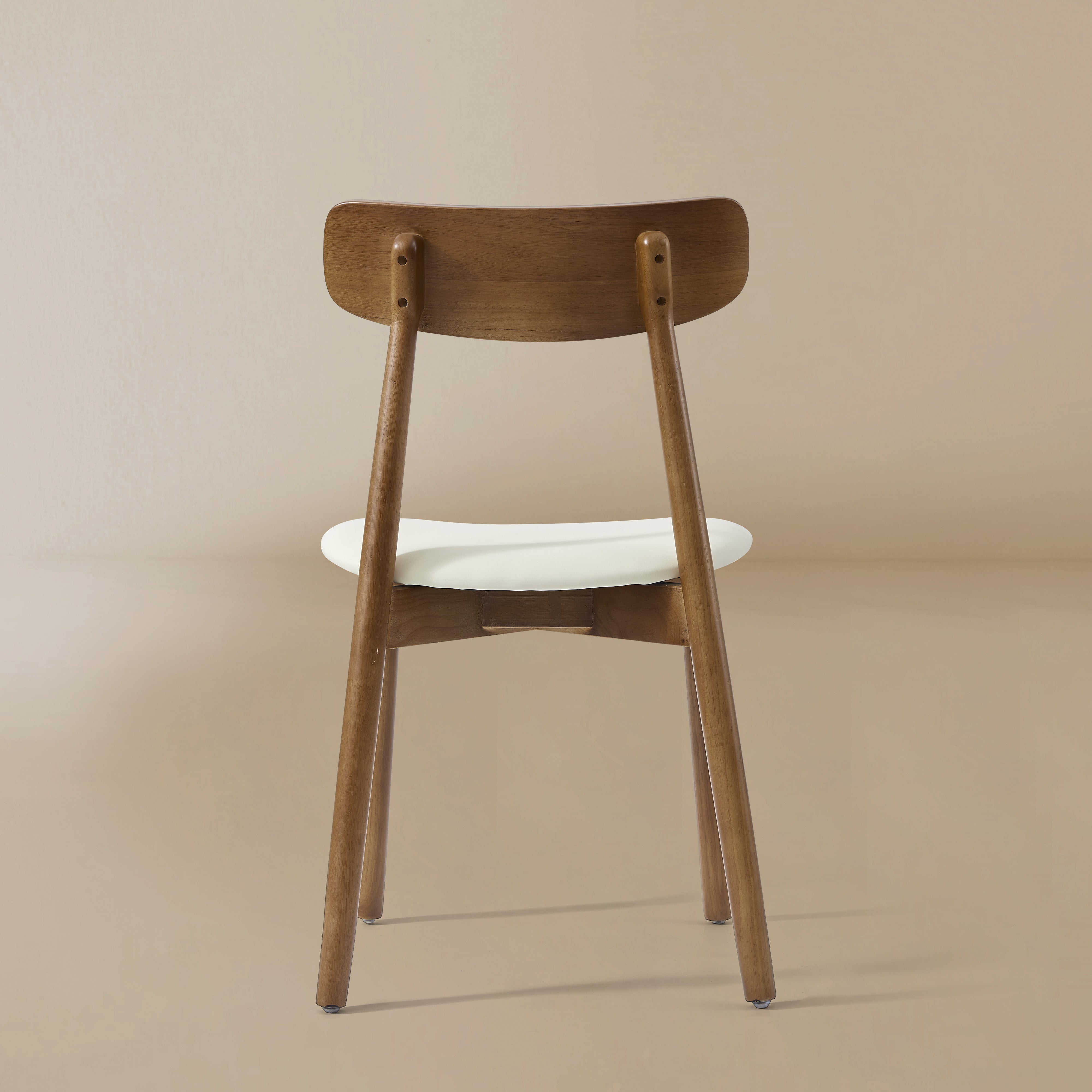 Back profile of the Ash Classic dining chair featuring a solid wood frame with a dark walnut finish, curved backrest, and cream upholstered seat.