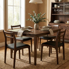 Four dark wood Aspen dining chairs with black seats styled around a square wooden dining table in a warm, earthy dining room