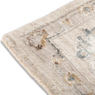 Corner detail of the Aurelia Vintage Floral Rug in Ivory showing the light floral border and soft fringed edge.