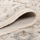 Rolled edge of the Aurelia Vintage Floral Rug in Ivory showing the plush pile, bound edge and woven underside.