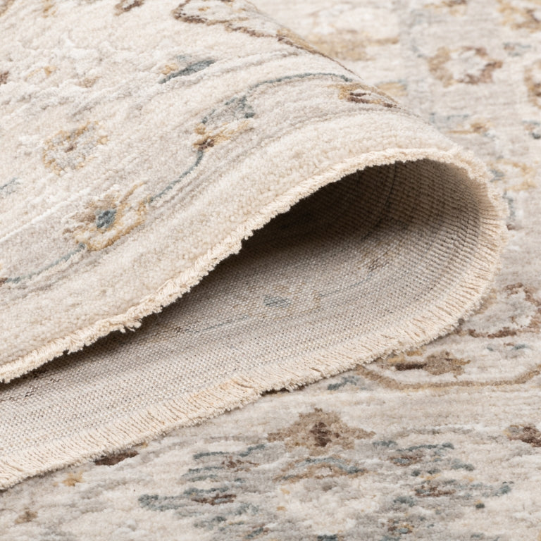 Rolled edge of the Aurelia Vintage Floral Rug in Ivory showing the plush pile, bound edge and woven underside.
