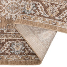Folded corner of the Aurelia Vintage Floral Rug in Mocha showing the patterned pile and woven backing.