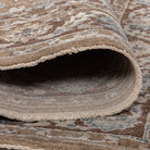 Rolled edge of the Aurelia Vintage Floral Rug in Mocha showing the soft pile, bound edge and woven underside.
