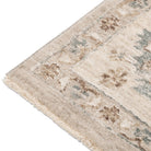 Close-up of the Aurelia Vintage Floral Rug in Sand showing its soft floral motifs in cream, beige, brown, and muted blue.