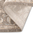 Folded corner of the Aurelia Vintage Floral Rug in Taupe showing the floral pile and woven backing.