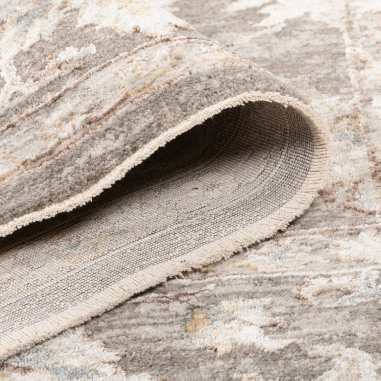 Folded Aurelia Vintage Floral Rug in Taupe showing the soft pile, finished edge, and woven backing.